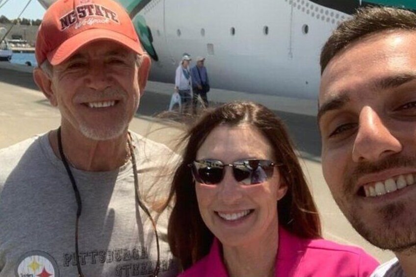 Three people in front of an airplane with a logo on the plane. 4
