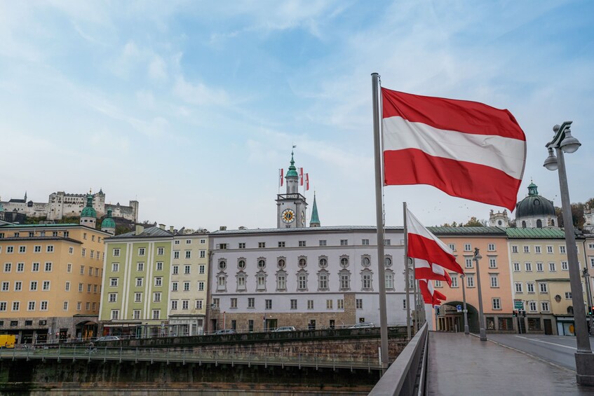 Eine Stadtansicht mit historischen Gebäuden, einem markanten Glockenturm und Flaggen. 5