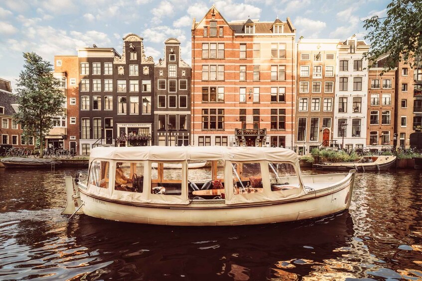 A canal boat with passengers, surrounded by historic buildings. 3