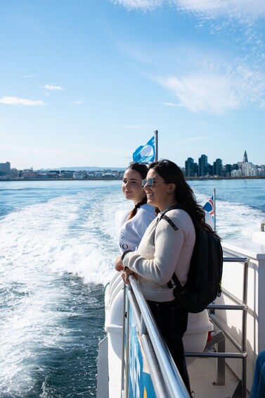 Two people on a boat with a city skyline in the background. 5