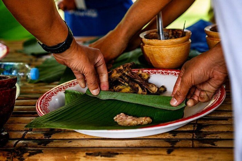 Iemand serveert eten op een bananenblad dat op een bord ligt. 2