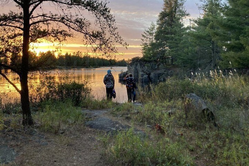 Ein Sonnenuntergang über einem See, zwei Personen stehen am Ufer. 5