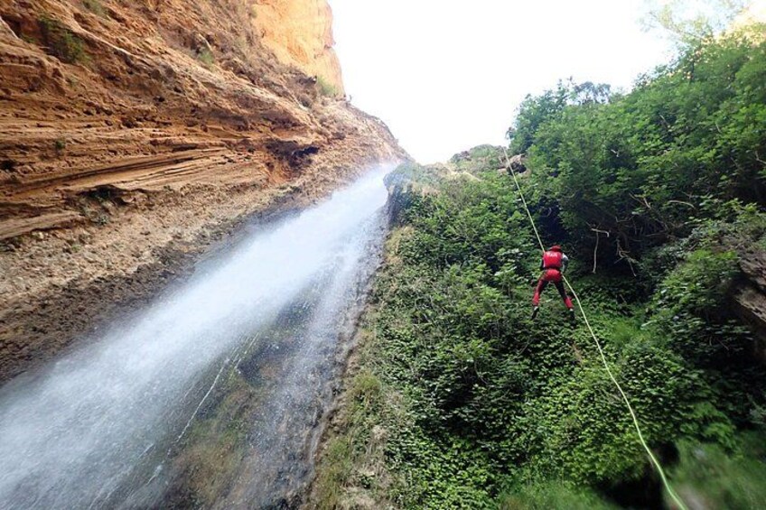 A person bungee jumping from a cliff with a waterfall below. 5