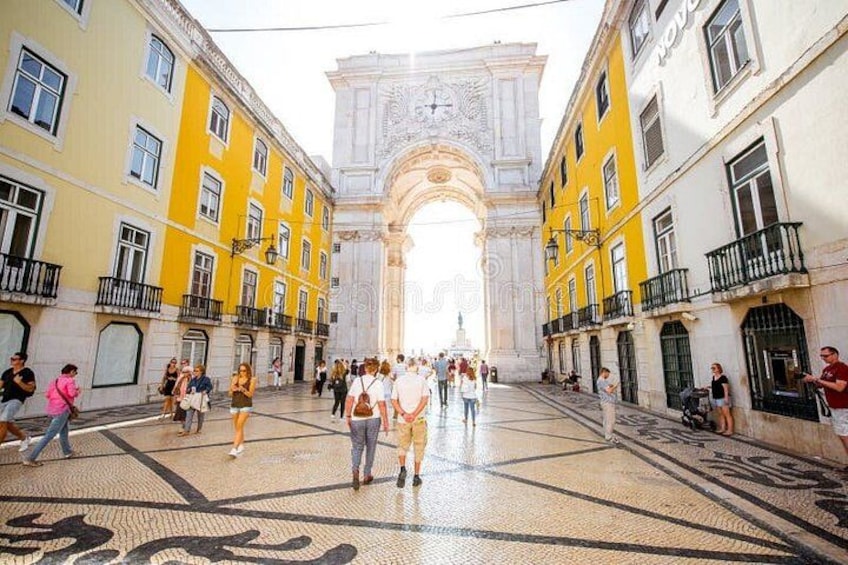Un arco histórico con personas caminando frente a él. 3