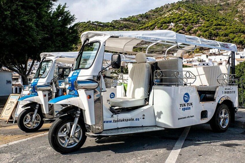 Un vehículo utilitario blanco y azul estacionado en una carretera, con un paisaje montañoso al fondo. 1