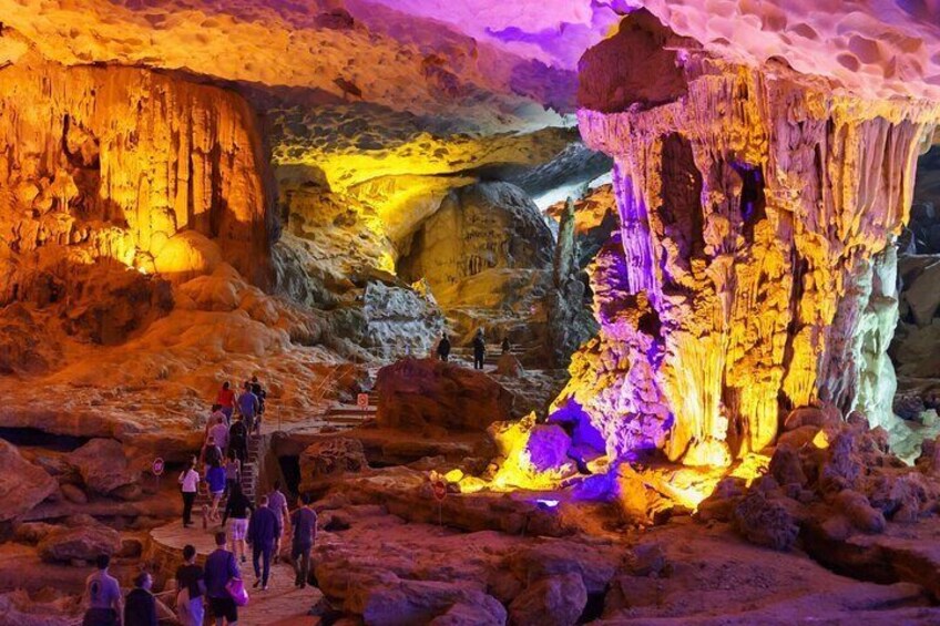 Una cueva con formaciones rocosas de colores y personas explorando. 4