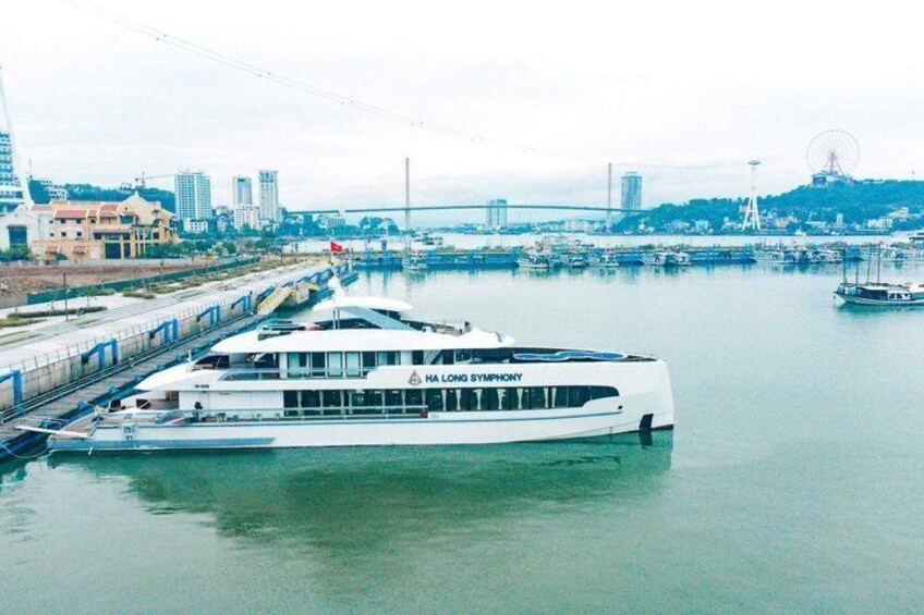 Un gran barco crucero blanco atracado en un muelle, con un paisaje urbano de fondo. 1