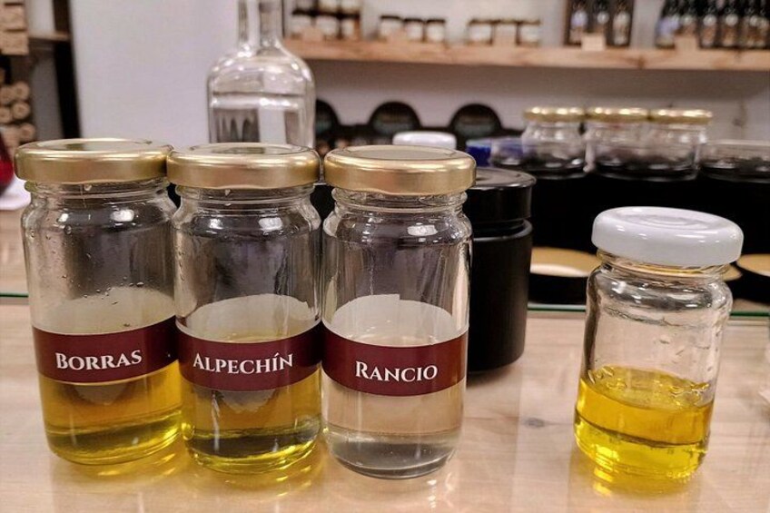 Three glass jars with labels on a table, one with a white cap, and a smaller bottle with a white cap. 2