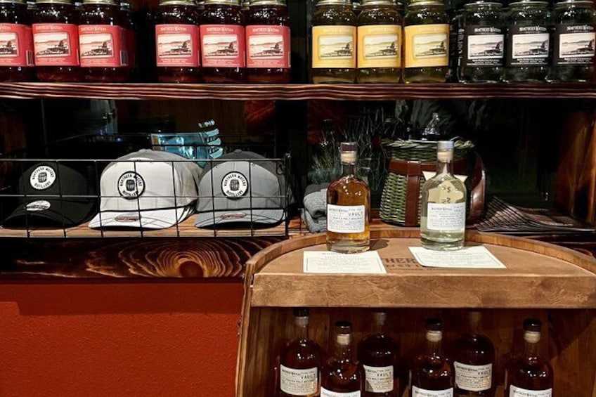 A bar with various bottles and jars of liquor on shelves and a counter. 4