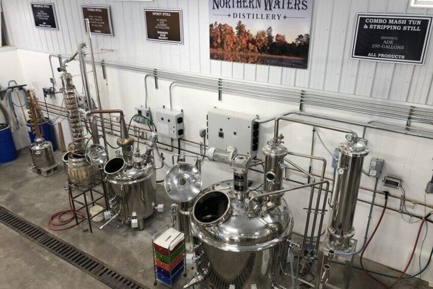A distillery with stainless steel equipment, pipes, and tanks. 1