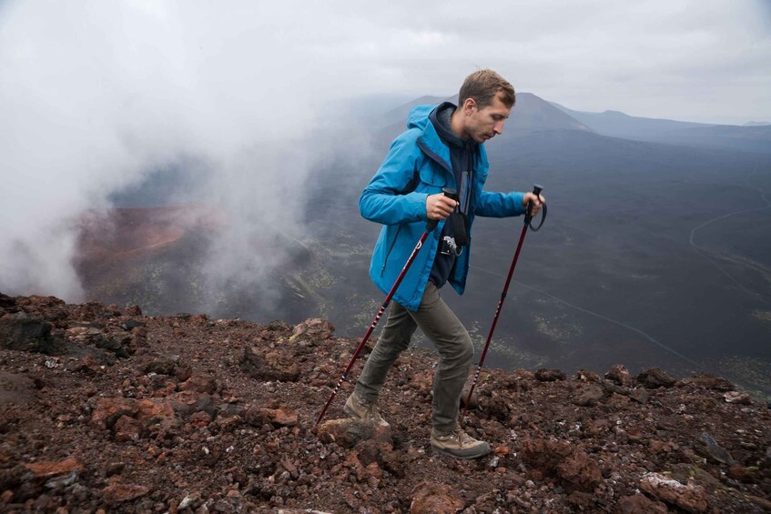 A person hiking on a rocky terrain with a mountainous landscape in the background. 5
