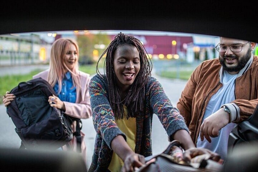 A group of people loading luggage into a car. 4