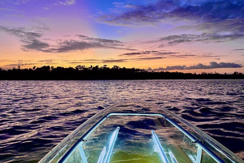 Un bote en el agua con un atardecer al fondo. 2