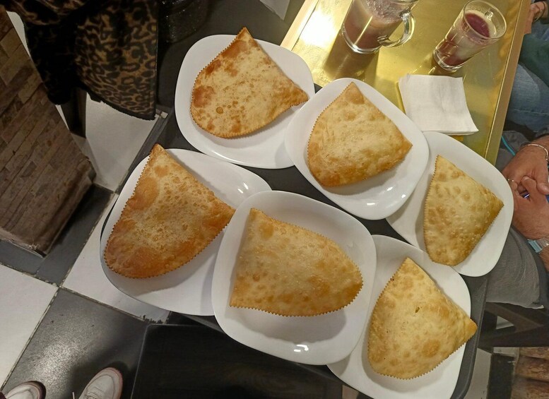 A table with triangular pastries on plates. 4