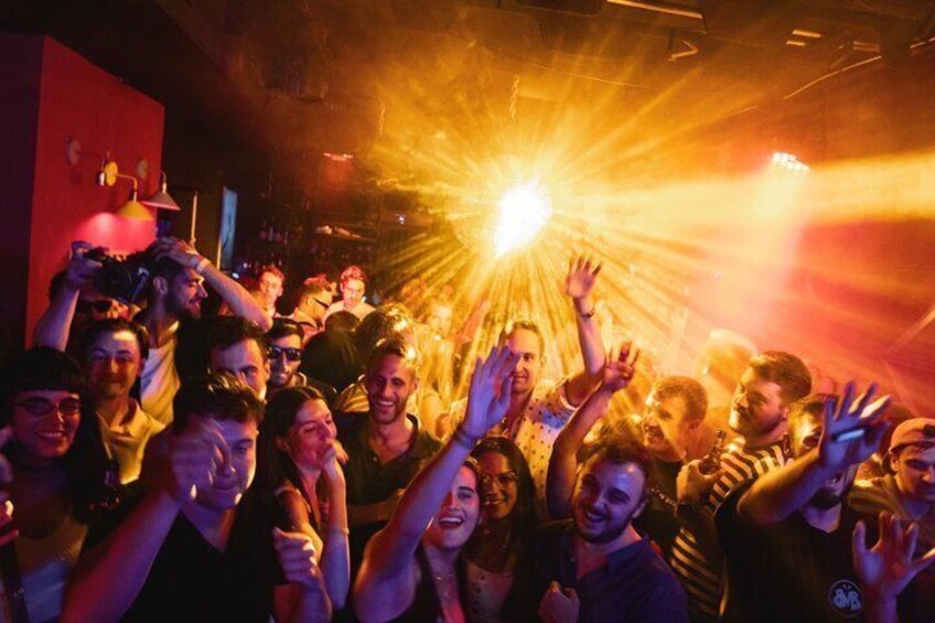 A crowded indoor space with people raising their hands, possibly at a concert or event. 2