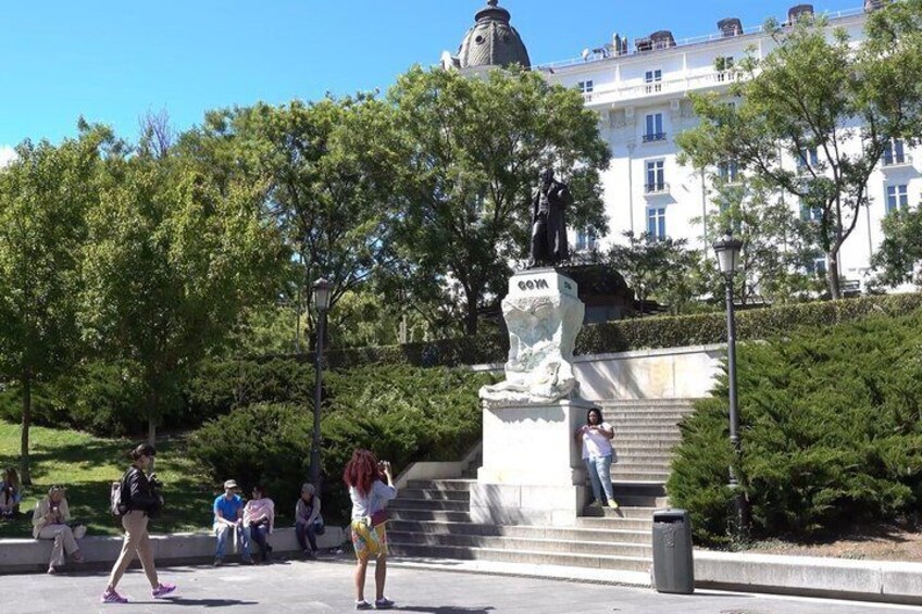 Una estatua en un parque, con gente caminando. 3
