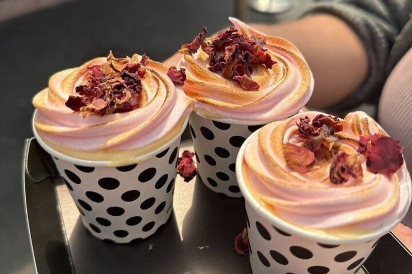 Three polka-dotted cups with frothy drinks topped with dried rose petals. 5