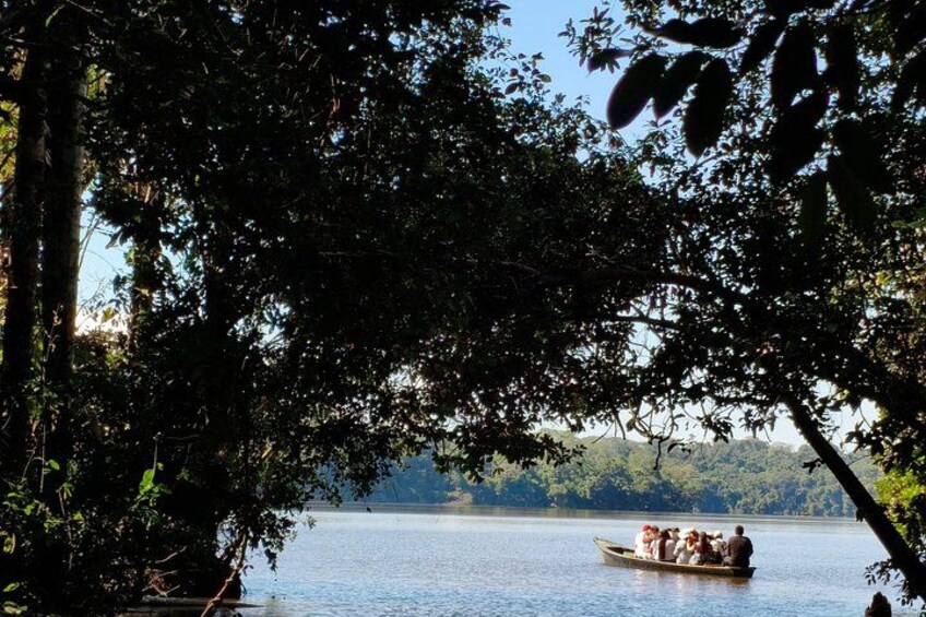 A calm lake with a boat carrying people. 4