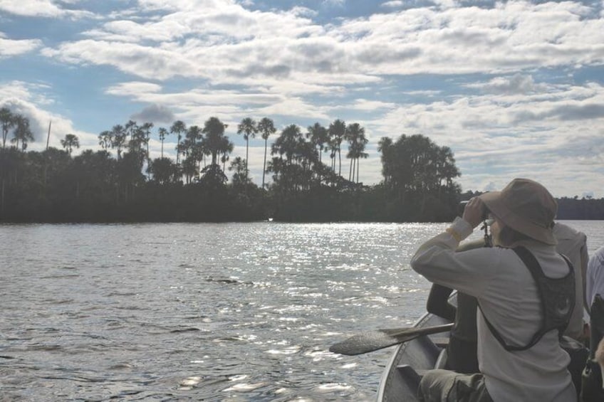 A person in a boat, wearing a hat and a jacket, looking at the water. 2