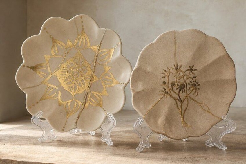 Two ceramic plates with intricate designs on a wooden surface. 3