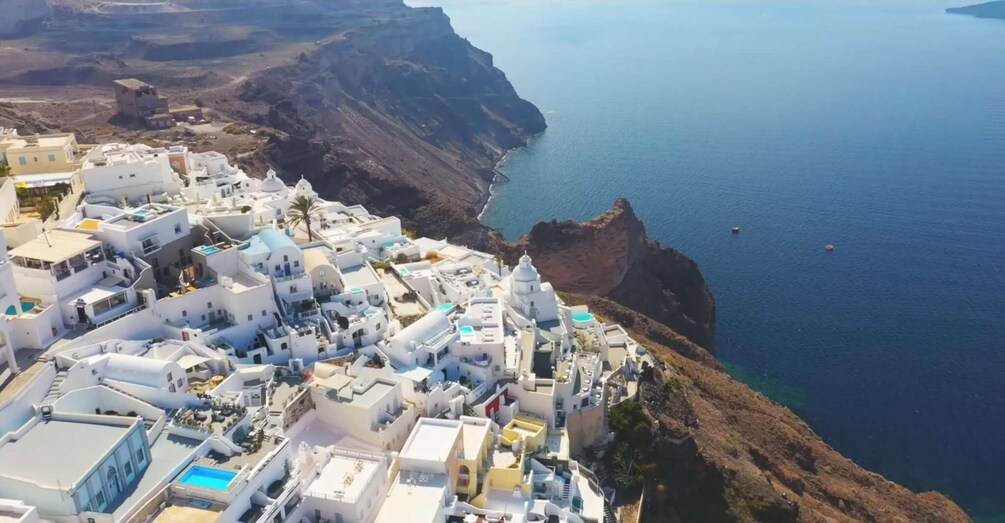 Un village côtier aux bâtiments blancs, surplombé par une falaise qui donne sur la mer. 4