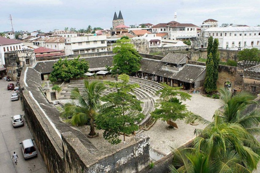 Una plaza histórica con una fuente, palmeras y edificios antiguos. 2