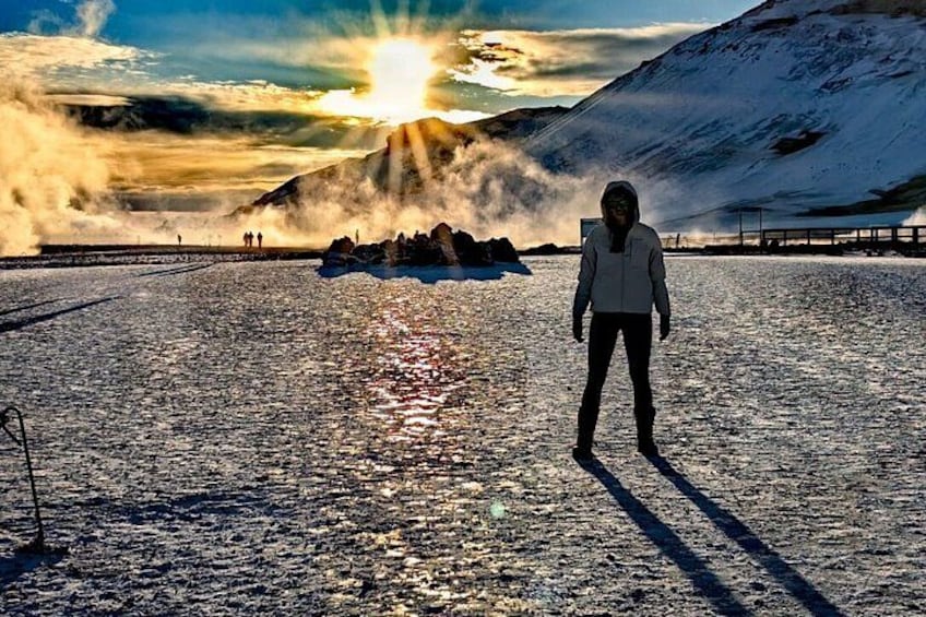 En person står på snedækket jord med solnedgang i baggrunden. 4