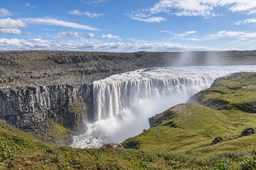 A waterfall cascading down a steep cliff into a valley. 1