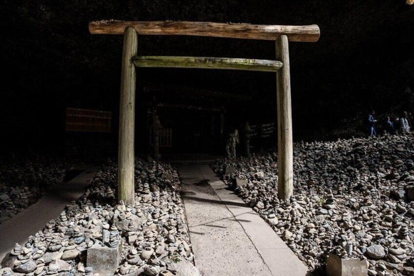 A stone pathway leading to a wooden archway surrounded by rocks. 4