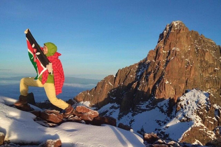 A person hiking on a snowy mountain with a flag. 2