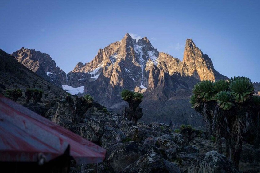 A rugged mountain landscape with prominent peaks, rocky outcrops, and sparse vegetation. 5