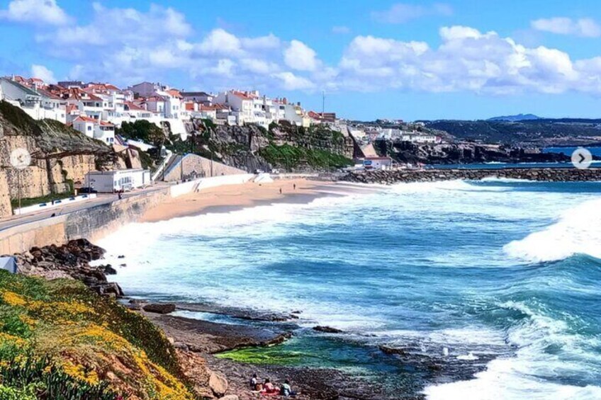 Un pueblo costero con playa, costa rocosa y edificios blancos. 5