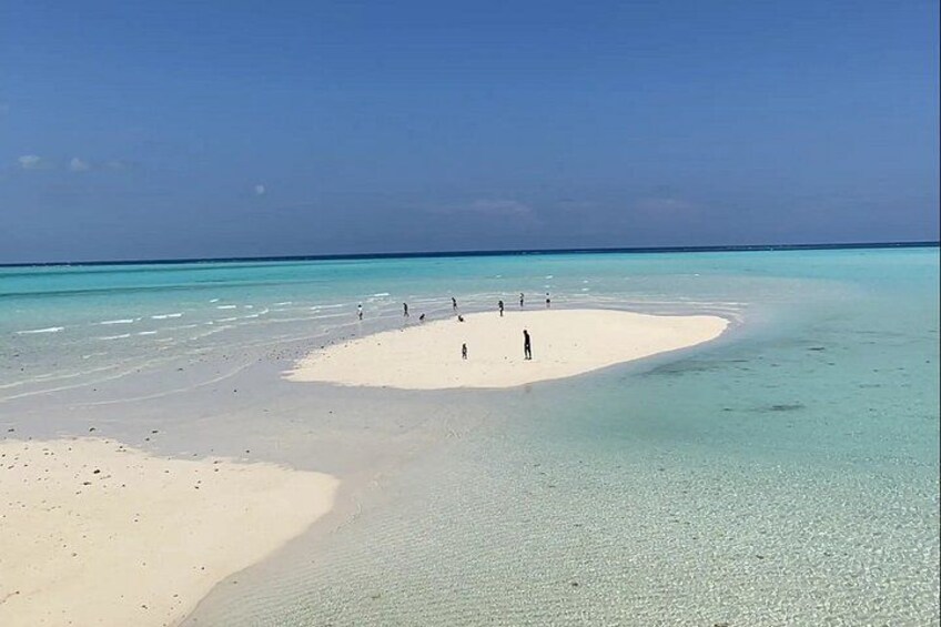 A beach with clear turquoise water and white sand. 4