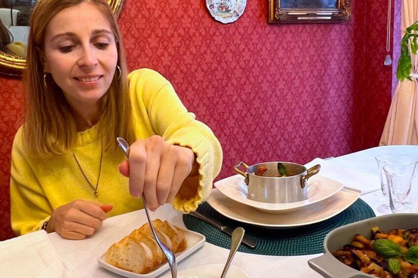 A person dining at a table with a bowl of soup, a plate of food, and a glass of water. 3