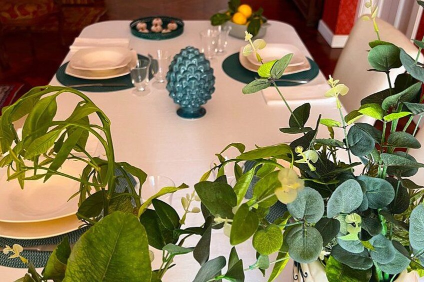 A table set for a meal with plates, glasses, and a decorative blue vase. 5