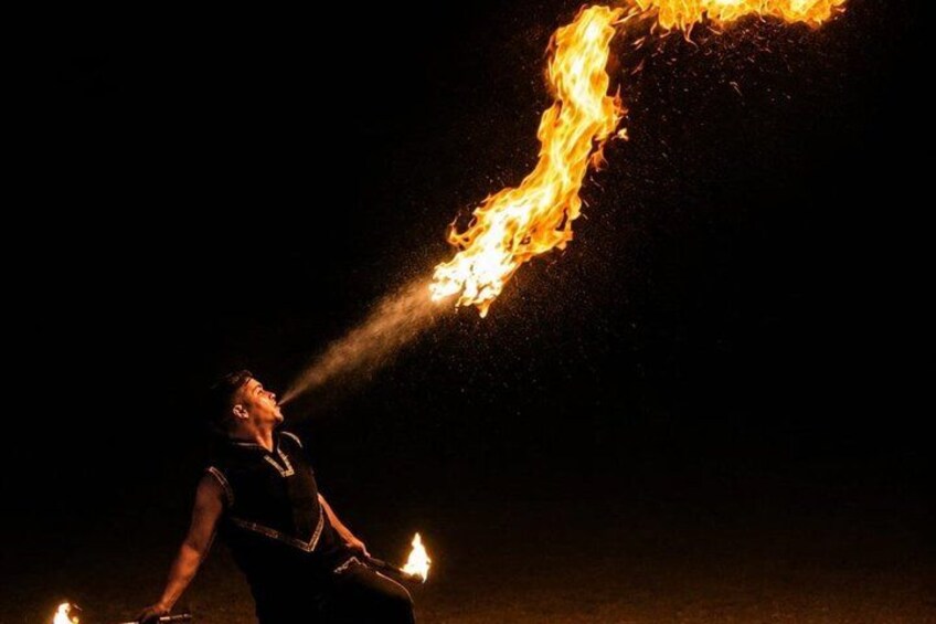 A person performing fire breathing with flames directed upwards. 4