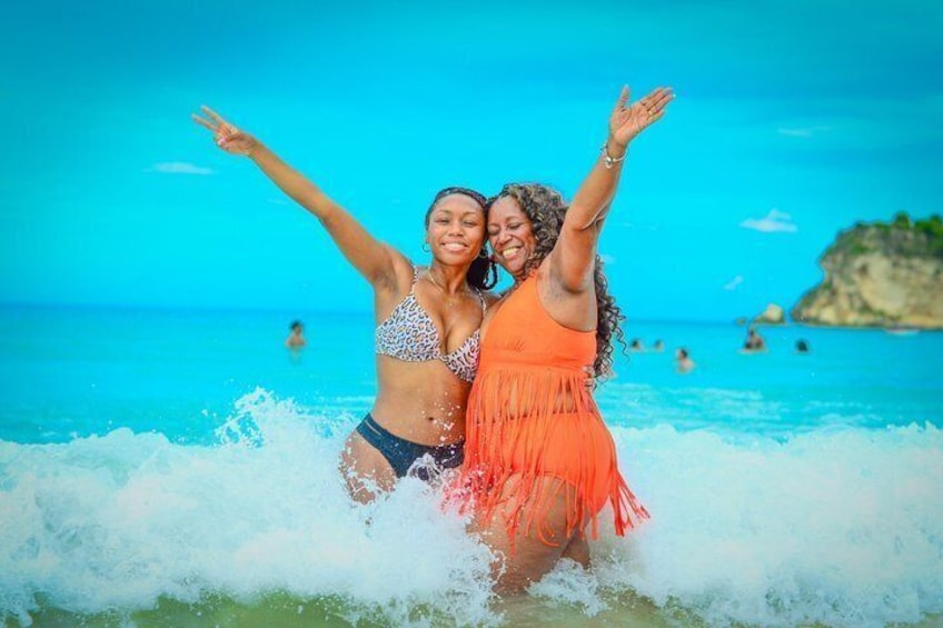 Due persone in bikini su una spiaggia con onde e cielo sereno. 2