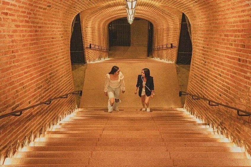 Una escalera de ladrillo con barandilla que sube a un nivel superior. 1