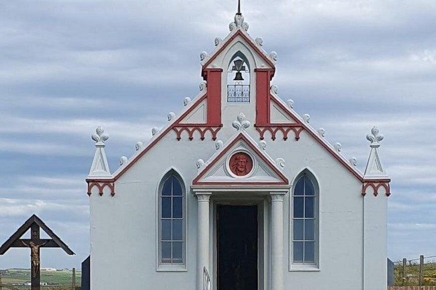 A white church with a red roof and a bell tower. 1