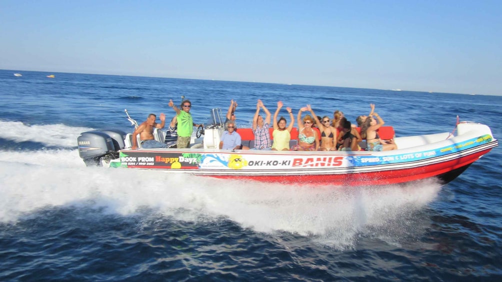 A group of people on a speedboat with 'OKI-KO-KI BRANIS' written on the side, enjoying a ride on the water. 2