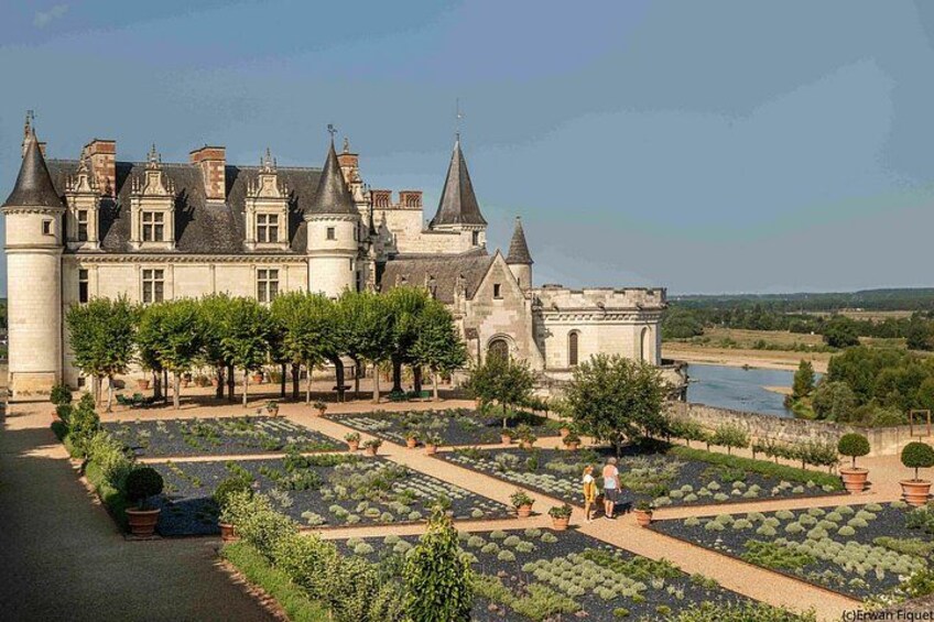 A historic building with a garden and a river in the background. 3