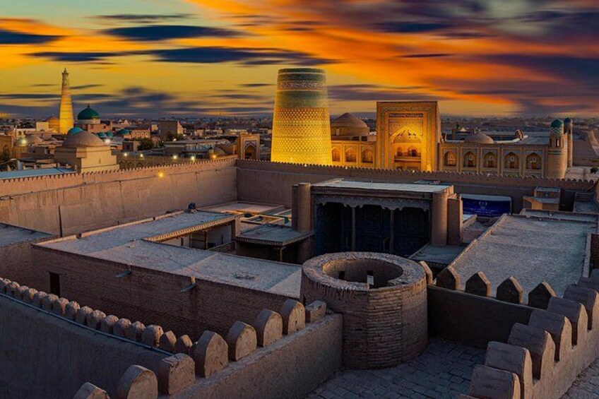 A historic cityscape with a prominent minaret, a large dome, and fortified walls. 3