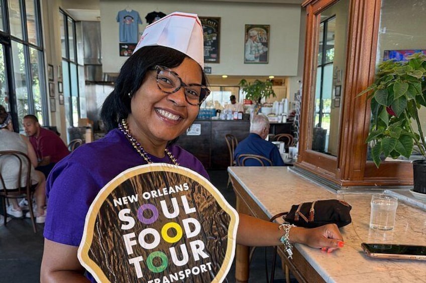 A person holding a sign for the New Orleans Soul Food Tour. 2