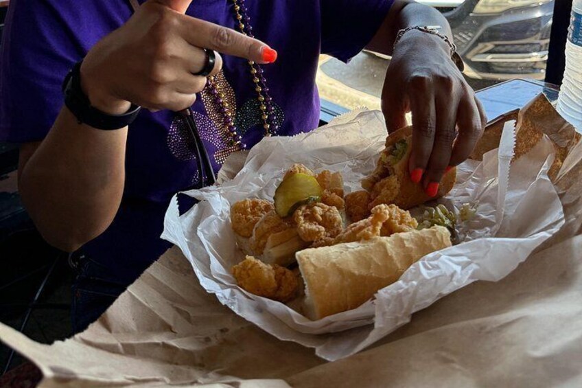 A person holding a basket of fried food, including chicken and bread. 4
