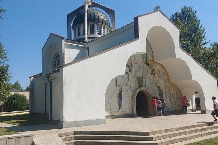 A church with a dome and a mural on the facade. 2