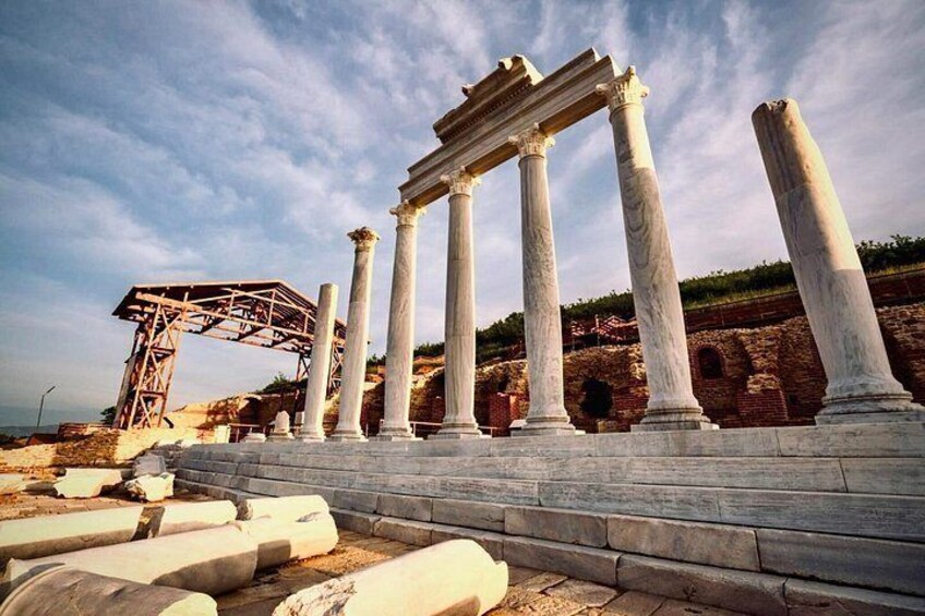 Columnas blancas antiguas, una estructura metálica y ruinas en un sitio histórico. 1