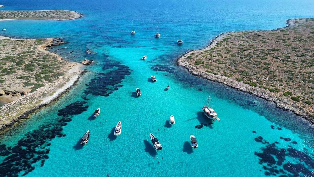 A turquoise sea with boats anchored near the shore. 1