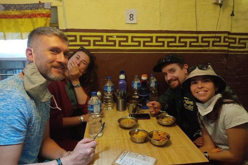 Een groep mensen zit aan een tafel met eten en drinken in een restaurant. 1