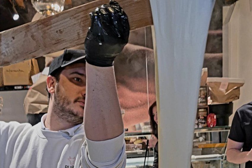 Una persona con una camisa blanca y guantes negros, sosteniendo un objeto negro. 2