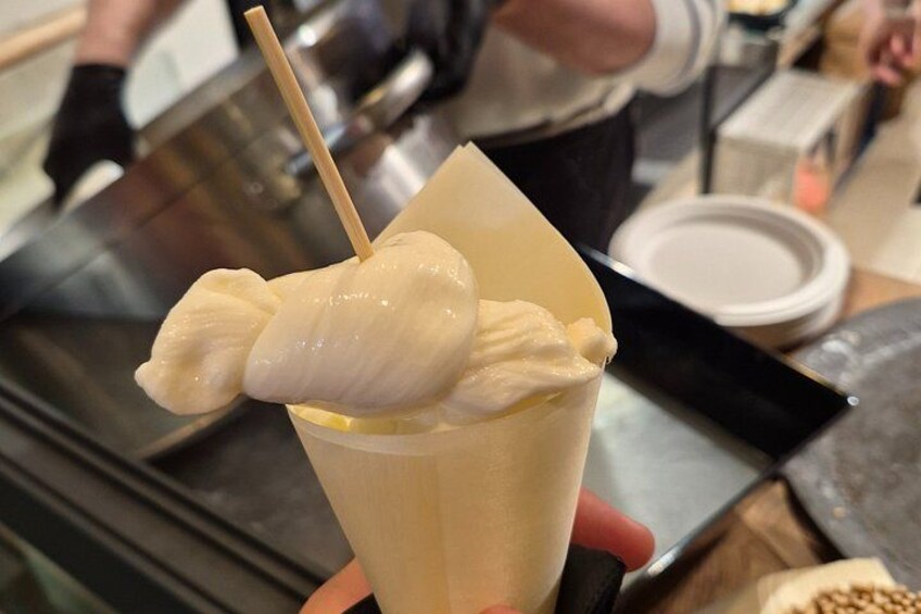 Un postre con textura cremosa y un palito de madera, servido en un vaso. 3